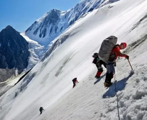 Group of climbers ascending a steep snowy slope with ice axes