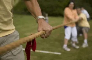 Close-up of a participant holding a rope during a tug of war game, available at North Sport Rentals