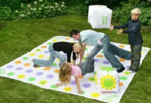 Kids playing an outdoor giant Get Knotted game with dice on a lawn, offered by North Sport Rentals