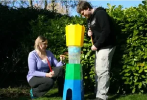 Two people playing a giant Kerplunk game outdoors, available for rent at North Sport Rentals