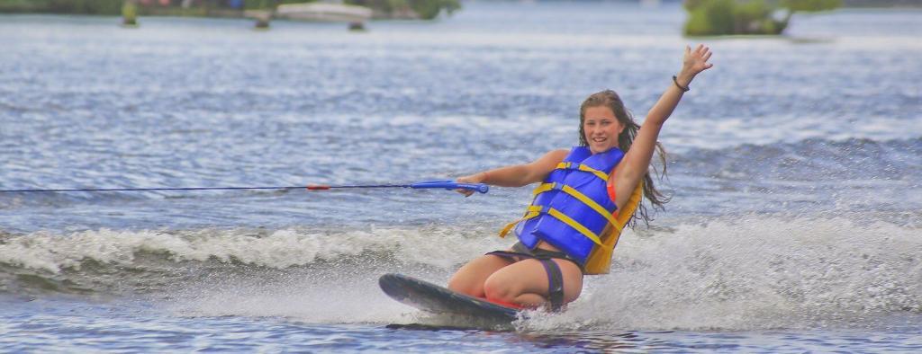 Young girl kneeboarding on a lake