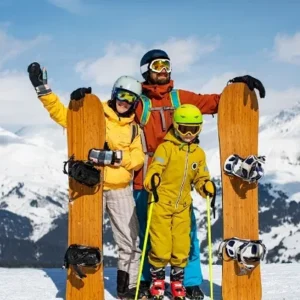 Family of three standing with snowboards and ski poles in Minnesota from North Sport Rentals