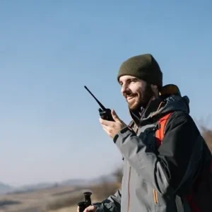 Hiker using a walkie talkie on an outdoor trail, North Sport Rentals communication gear in Minnesota