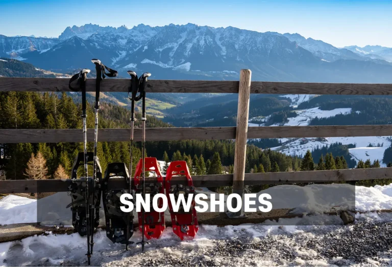 Snowshoe Rentals - North Sport Rentals, Minnesota - North Sport Rentals Snowshoes and trekking poles resting against a wooden fence with a scenic mountain landscape in the background.