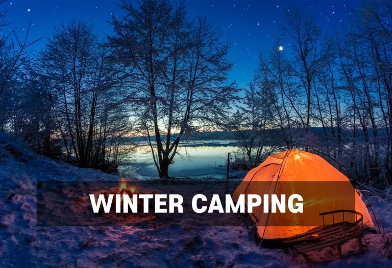 Winter Camping Gear Rentals - North Sport Rentals, Minnesota - North Sport Rentals Orange tent illuminated at night in a winter forest setting, with a campfire nearby and a serene lake in the background under a starry sky.