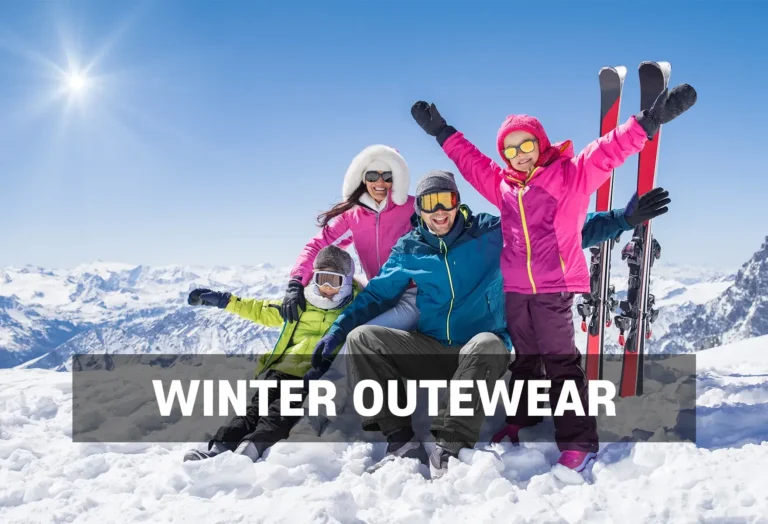 Winter Outerwear Rentals - North Sport Rentals, Minnesota - North Sport Rentals Family dressed in vibrant winter outerwear, sitting on a snowy mountaintop with ski gear, enjoying a sunny day in the mountains.