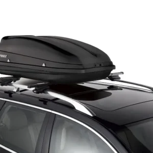 A sleek black Thule cargo box securely mounted on the roof of a modern vehicle.