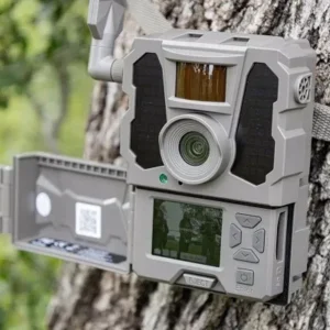 Close-up of a mounted trail camera with a built-in LCD screen and solar panels.
