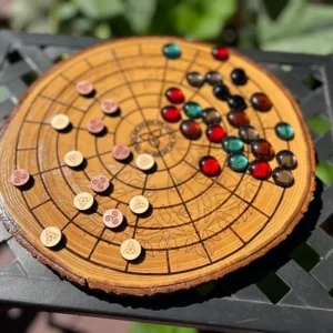 A full wooden strategy board in play with symbolic wood pieces and colored glass tokens, placed outdoors on a metal table.