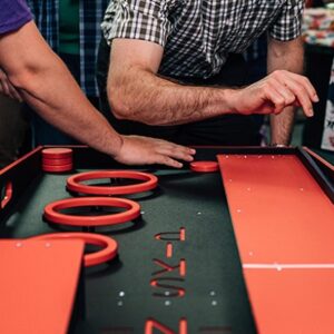 Tabletop and carnival games set up under a tent at a community festival